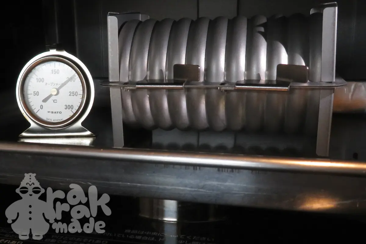 オーブンの中に設置した状況。高さ9センチのケーキ型の上にベーキングトレイを置いて、その上にラウンド型設置。